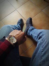 Low section of man standing on tiled floor