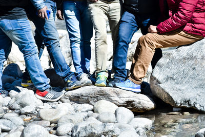 Low section of people sitting on rock