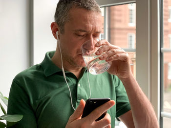 Young man using mobile phone at home