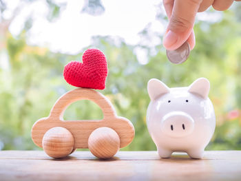 Cropped hand of woman holding piggy bank