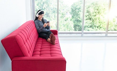 Young woman sitting on sofa at home