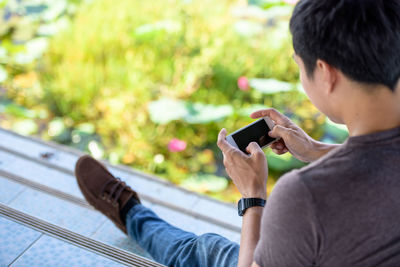 Midsection of man using mobile phone