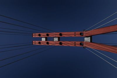 Low angle view of telephone pole against clear blue sky