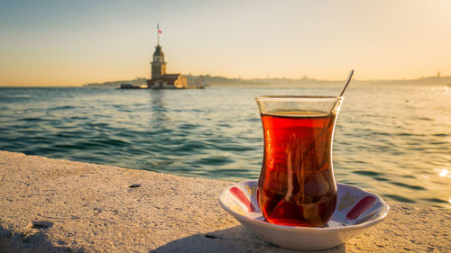 A cup of tea in istanbul's seaside watching the sunset over the maiden's tower in the bosphorus
