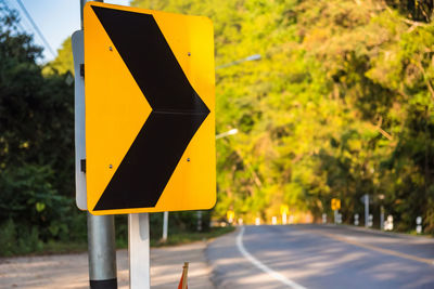 Road sign against trees in city