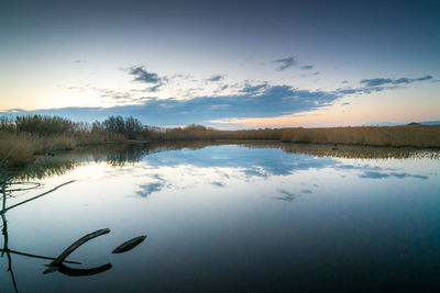 Scenic view of lake against sky at sunset