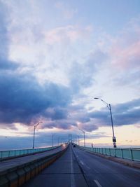 Road by bridge against sky during sunset