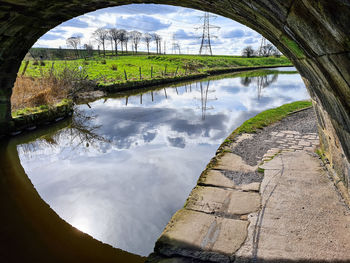 Arch bridge over lake against sky