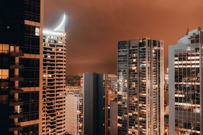 Illuminated buildings in city against sky at night