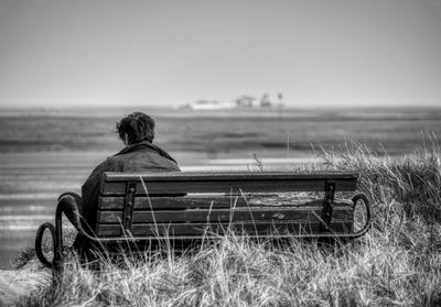 Rear view of man sitting on land