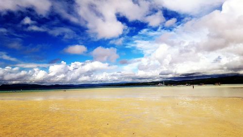 Scenic view of beach against cloudy sky