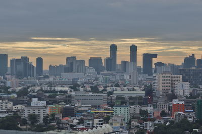 Aerial view of buildings in city against sky during sunset