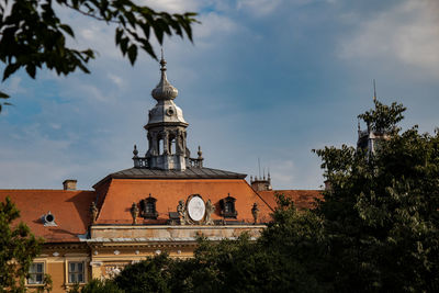 Low angle view of trees and buildings against sky