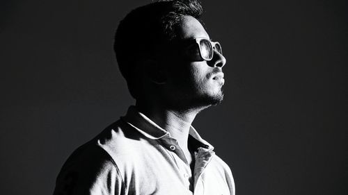Portrait of young man against black background