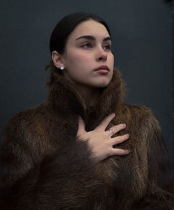Portrait of young woman against wall