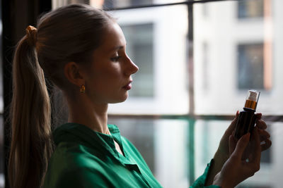 Side view of young woman drinking glass