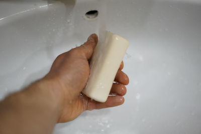 Midsection of person holding hands in bathroom