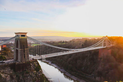 Bridge over river against sky during sunset