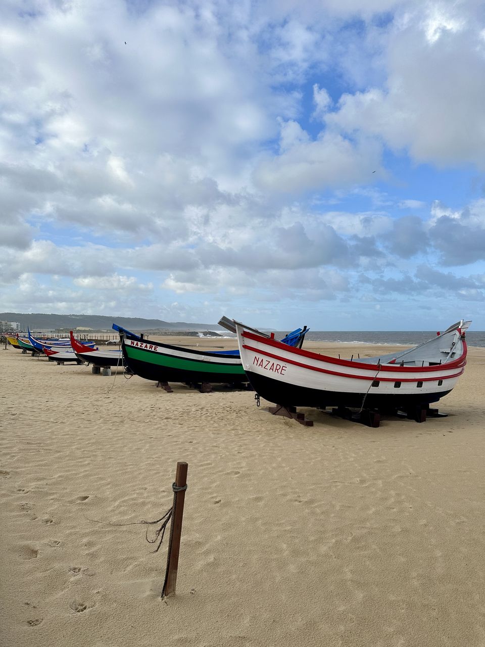 beach, nautical vessel, sand, land, water, transportation, sky, cloud, sea, mode of transportation, nature, shore, boat, moored, long-tail boat, vehicle, scenics - nature, coast, tranquility, travel, beauty in nature, day, no people, outdoors, travel destinations, tranquil scene, boating, ocean, holiday, non-urban scene, watercraft, vacation, trip, blue, tourism, absence