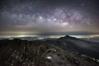 Scenic view of mountains against star field at dusk