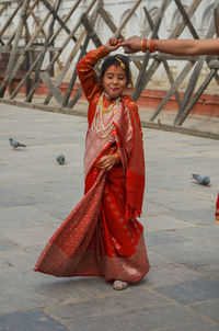 Full length of girl dancing while holding mother hand on floor