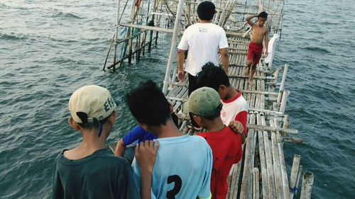 Rear view of people enjoying in sea