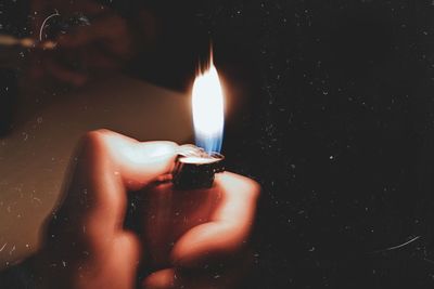 Blurred image of person holding illuminated cigarette lighter at night