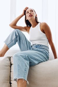 Young woman sitting on sofa at home