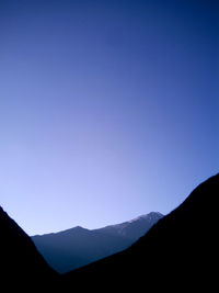 Scenic view of silhouette mountains against clear blue sky