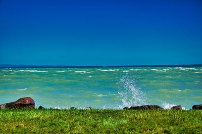 Scenic view of sea against clear blue sky