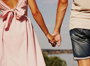 Midsection of couple holding hands