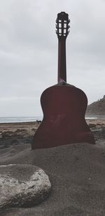 Rock formation on beach against sky