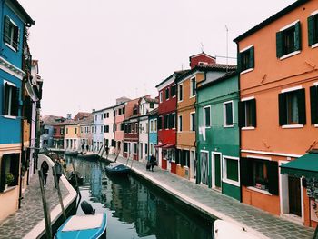 View of canal amidst buildings against sky