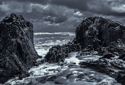 Scenic view of rocks in sea against sky