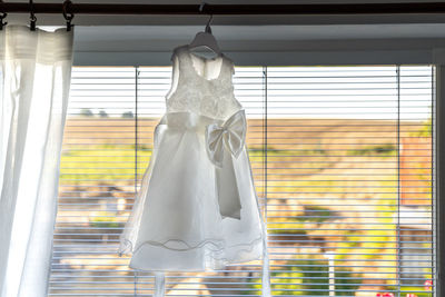 Close-up of dress hanging by window