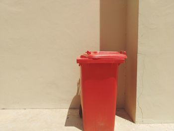 Close-up of red bell on table against wall