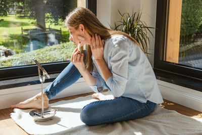 A young woman makes a facial massage with a quartz roller, a gouache scraper. facial skin care. 