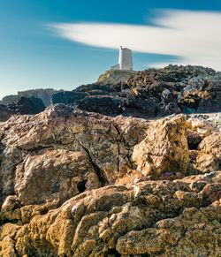 Rock formations by building against sky