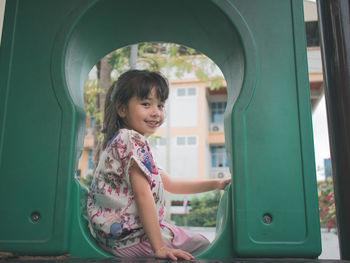 Side view of a smiling girl sitting outdoors
