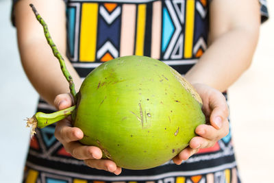Close-up of woman holding coconut 