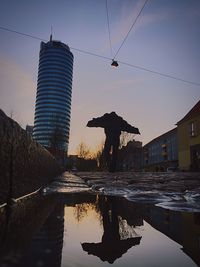 Reflection of built structures in water at sunset