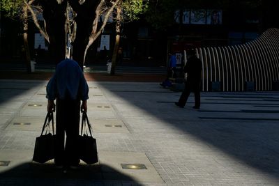 Woman standing on sidewalk at night