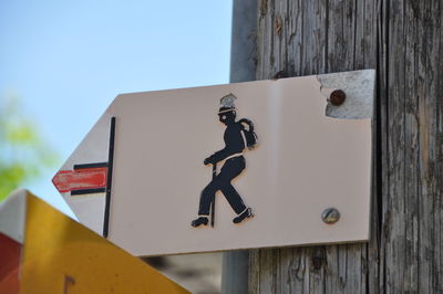 Information sign on wall by building against clear sky