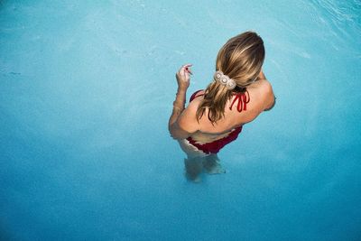 Rear view of woman wearing bikini in swimming pool