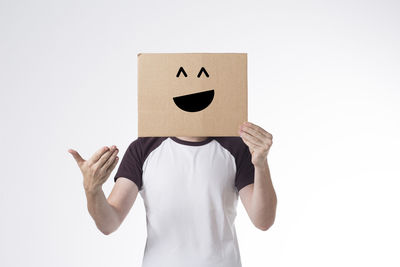 Midsection of person holding paper against white background
