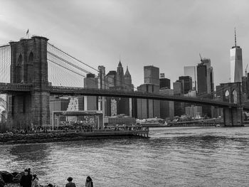 Bridge over river against buildings in city