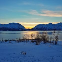 Scenic view of frozen lake against sky during sunset