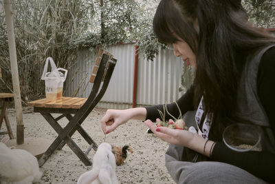 Side view of young woman with dog at home