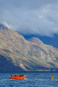 Scenic view of lake by mountains against sky