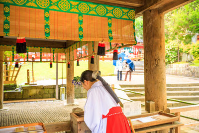 Rear view of woman sitting in temple